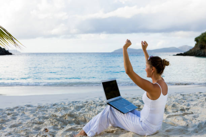 Woman uses laptop at the beach